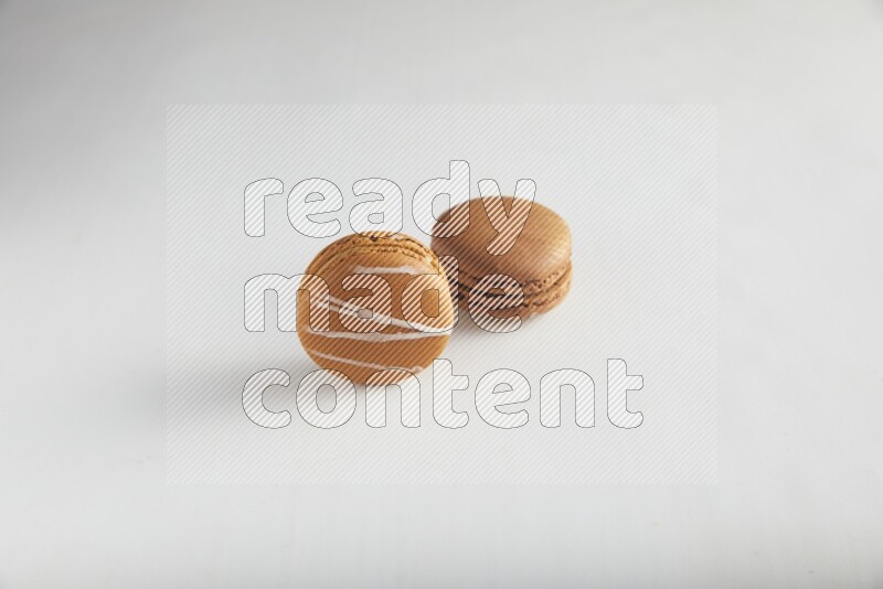 45º Shot of of two assorted Brown Irish Cream, and Brown Coffee macarons  on white background