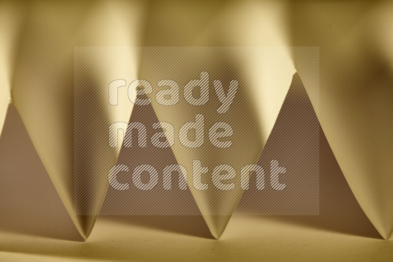 صورة مجردة مقربة تظهر طيات ورقية هندسية حادة بتدرجات الوان دافئة