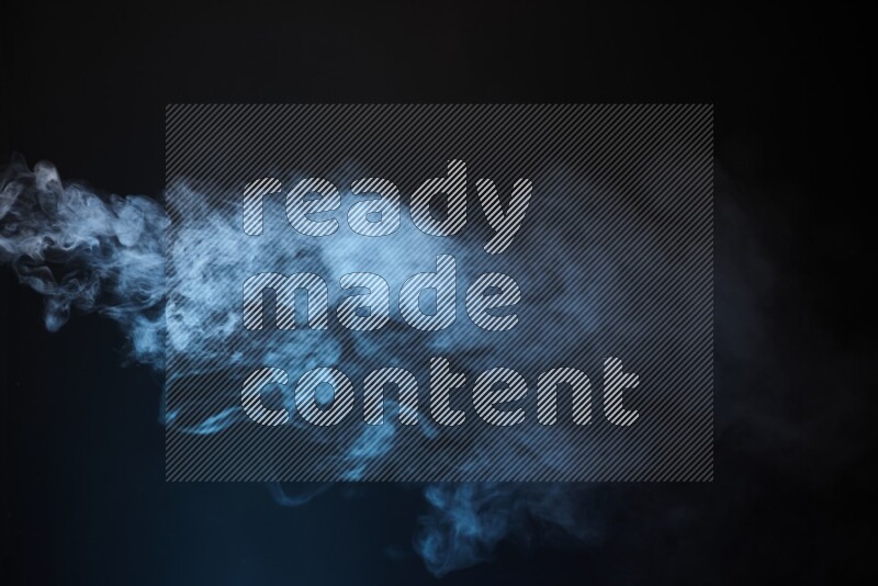 Heavy smoke in blue isolated on black background
