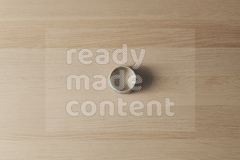 وعاء فخاري متعدد الألوان على خلفية خشبية فاتحة