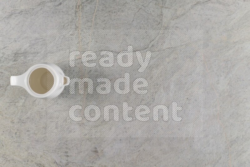 A ceramic milk jug on grey marble background