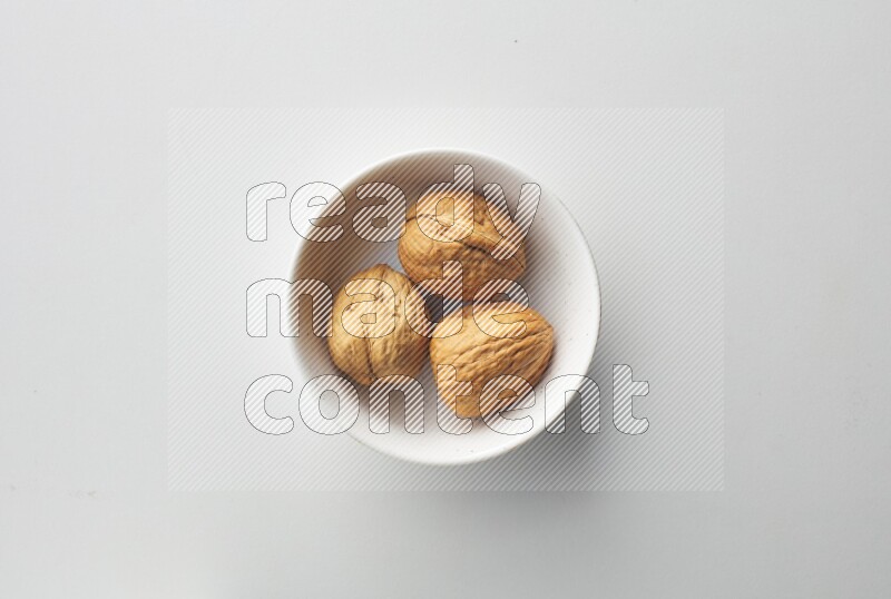 Top-view shot of walnut in a container on white background