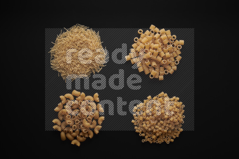 Different pasta types in bunches on black background