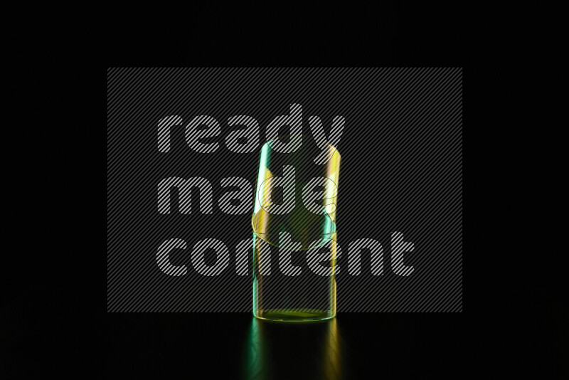 Glassware with rim light in green and yellow against black background