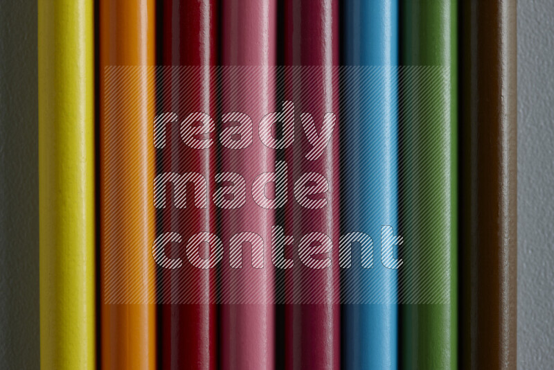 مجموعة من أقلام الرصاص الملونة مرتبة لتعرض تدرجا من الألوان المختلفة علي خلفية رمادية