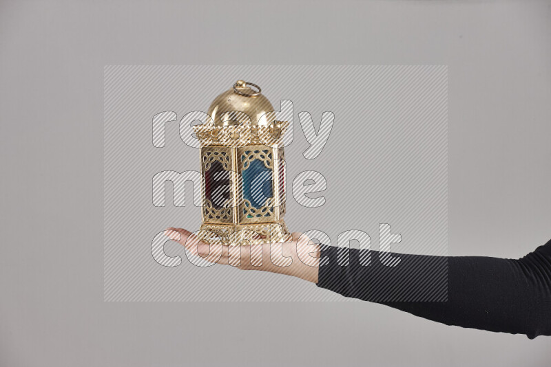 A woman in black abaya holding different ramadan lanterns in different positions