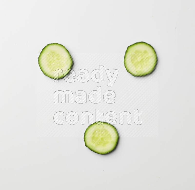 three cucumber slices on white background