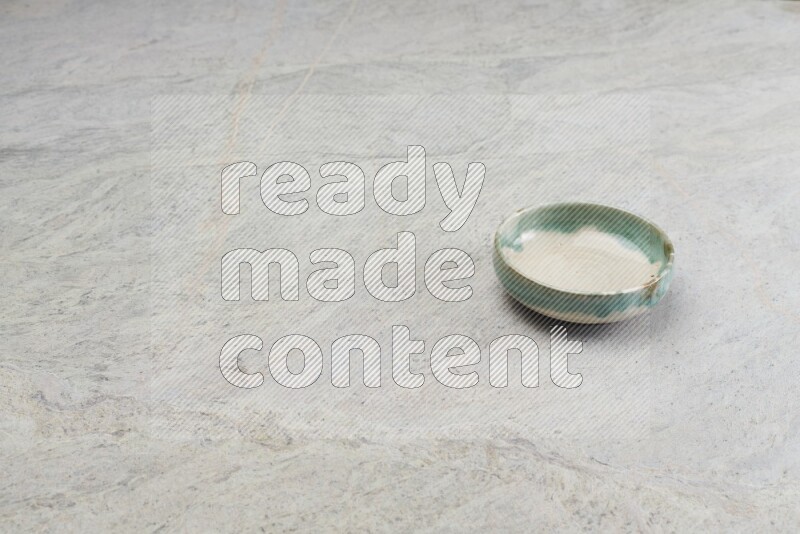 A multicolored pottery bowl on grey marble background