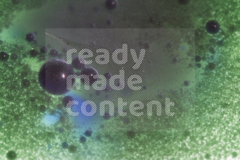 لقطات مقربة لقطرات ألوان مائية خضراء وزرقاء على سطح الزيت على خلفية بيضاء