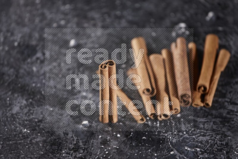 Cinnamon sticks on a textured black background