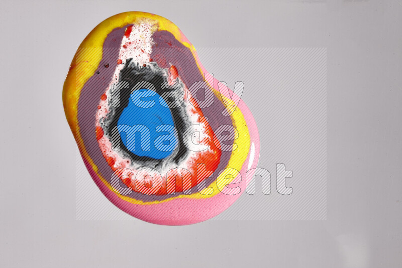 لقطات مقربة لألوان متنوعة تمتزج على خلفية رمادية