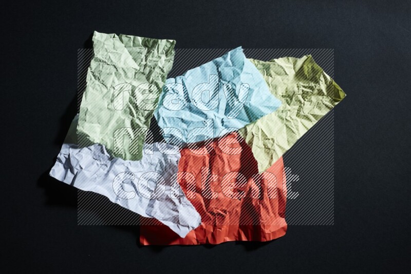 Crumpled multicolored paper on black background