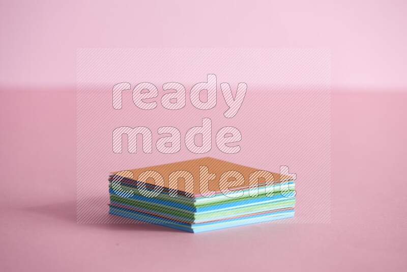 Stacked multicolored sticky notes on rose background
