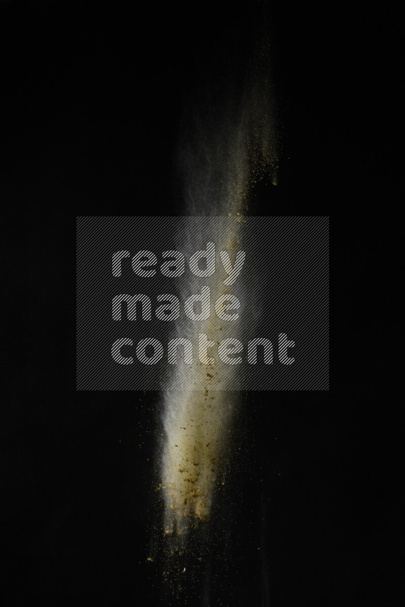 A side view of yellow powder explosion on black background