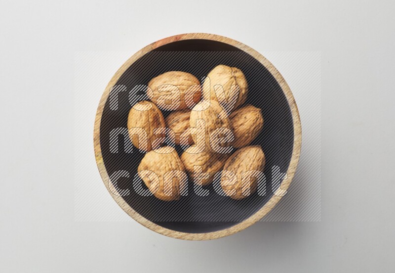 Top-view shot of walnut in a container on white background