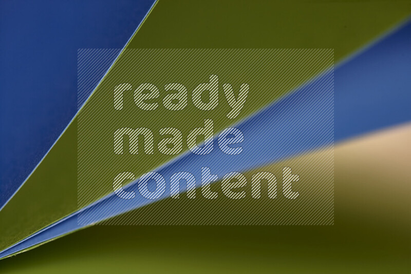 An abstract art showing blue and green paper sheets arranged in an overlapping curves