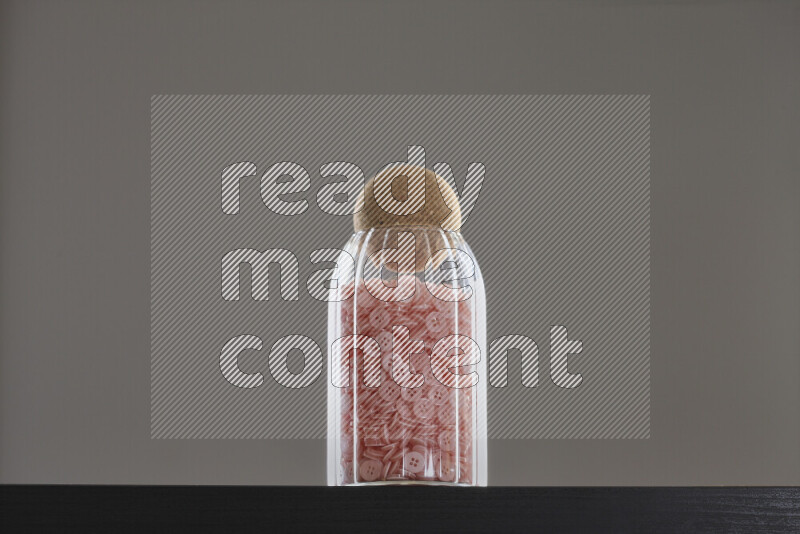 أزرار متنوعة في وعاء زجاجي علي خلفية سوداء