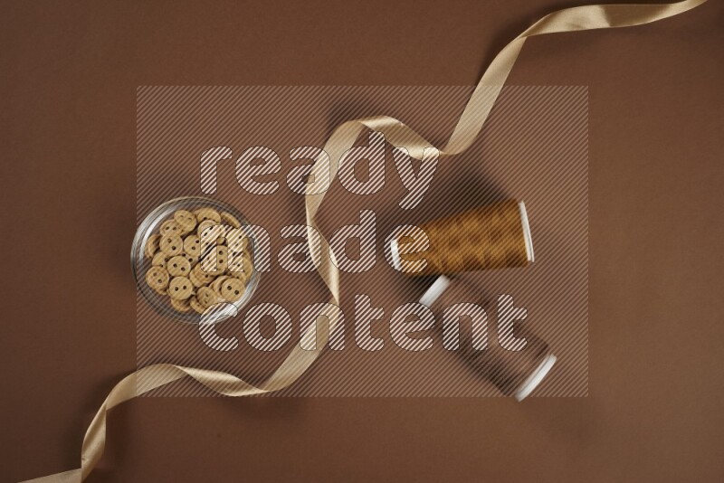 A brown collection of sewing and tailoring tools arranged on a brown background