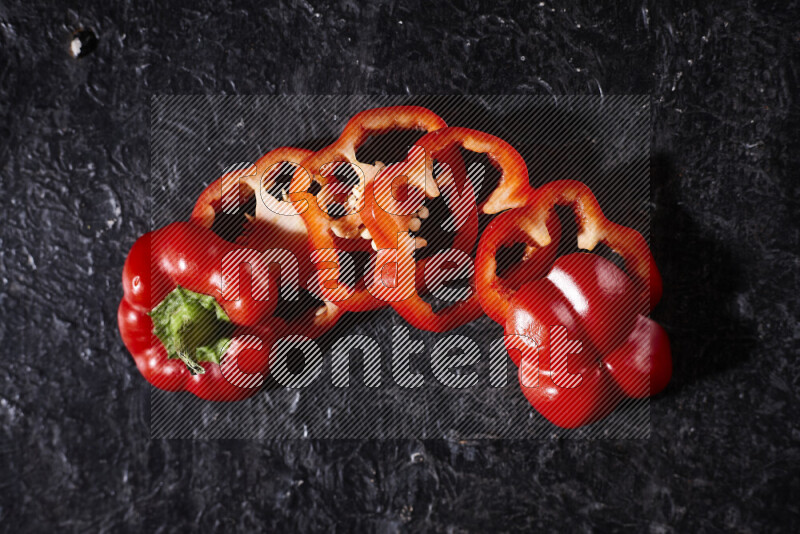 Red bell pepper slices on black background