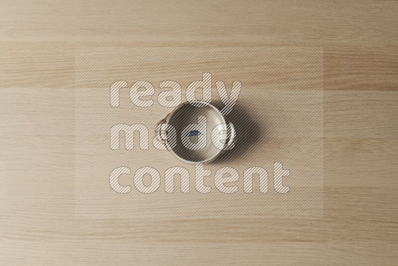A multicolored pottery bowl on light wooden background