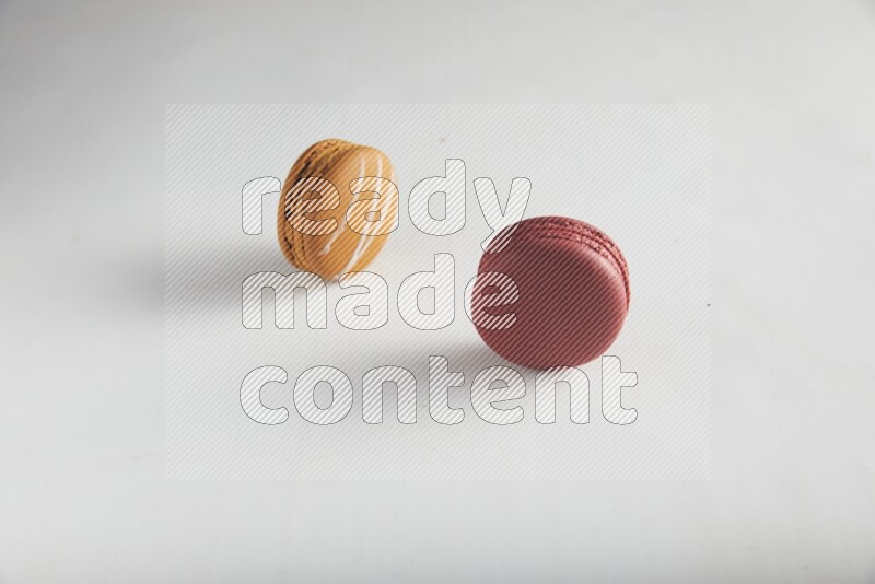 45º Shot of of two assorted Brown Irish Cream, and Red Velvet macarons on white background