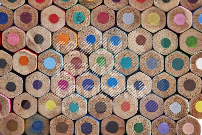 A close-up of the tips of colored pencils arranged in a bundle on white background