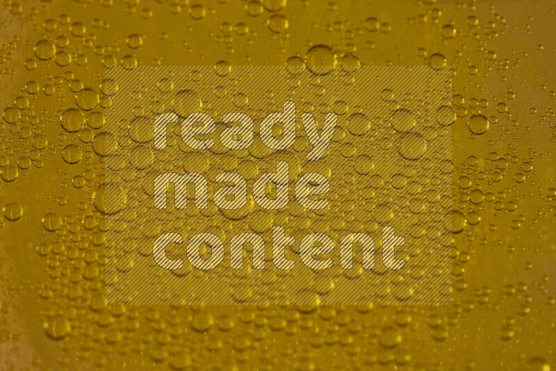 Close-ups of abstract water drops on oil Surface on yellow background