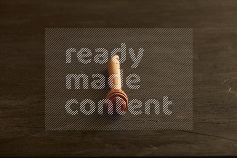 Wooden honey dipper on black slate background