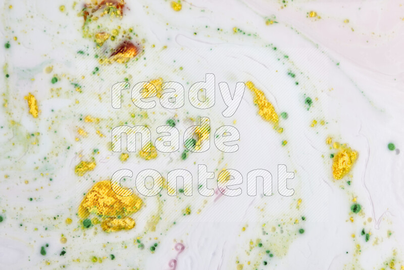 The image captures a splatter of yellow, red and green paint over a white backdrop