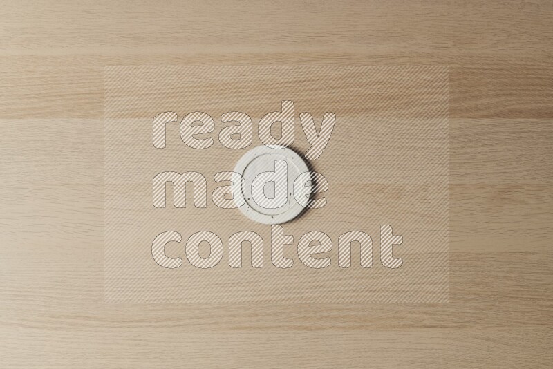 A pottery coaster on light wooden background