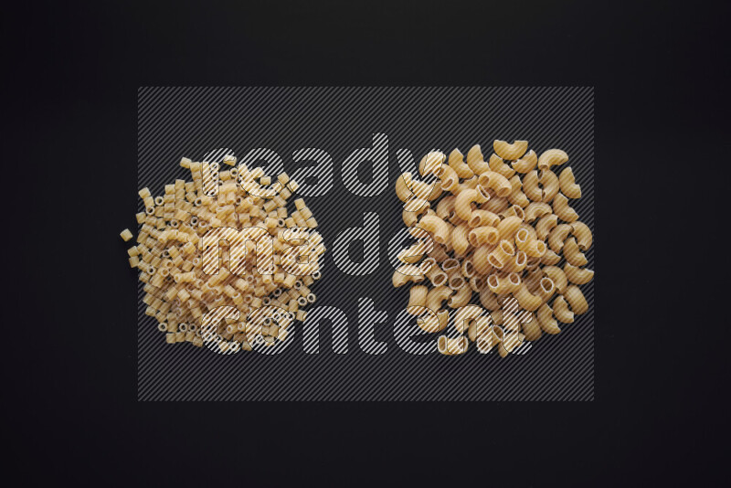 Different pasta types in bunches on black background