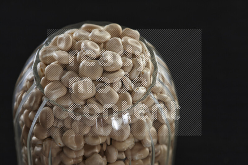 Lupin Beans in a glass jar on black background
