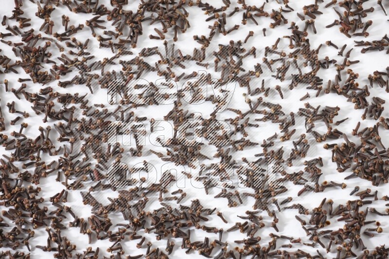 Cloves spread on white flooring