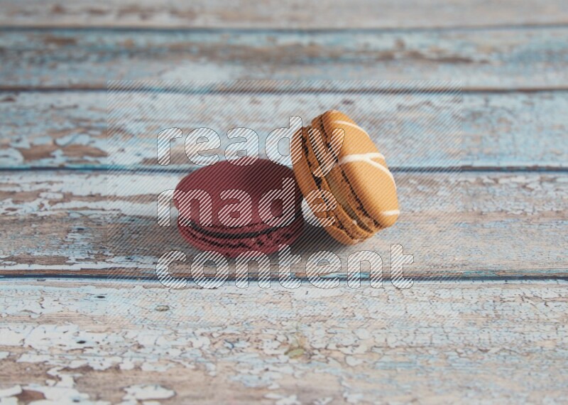 45º Shot of of two assorted Brown Irish Cream, and Red Cherry macarons  on light blue background