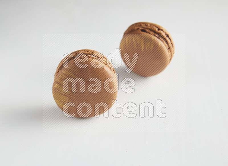 45º Shot of two Brown Coffee macarons on white background