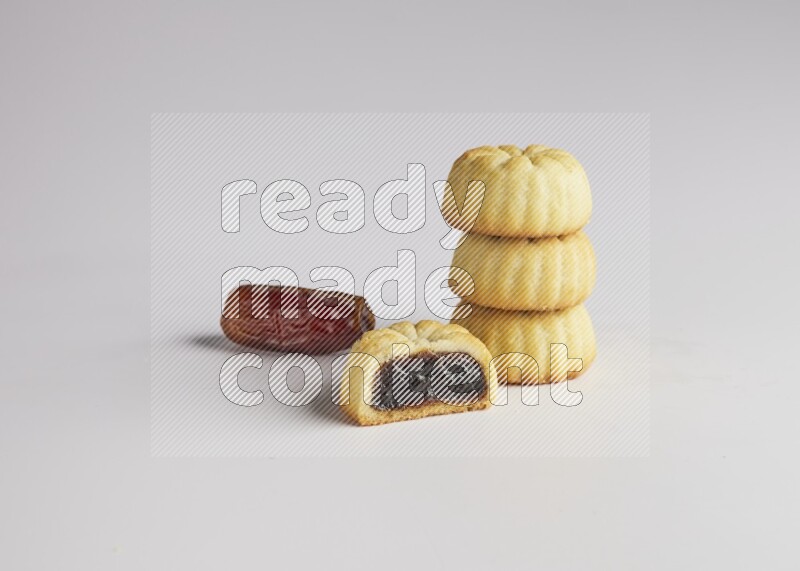 Four Pieces of Maamoul filled with date one of them is cut direct on white background