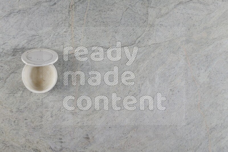 A multicolored pottery Cup on grey marble background
