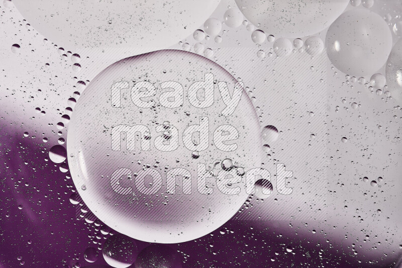 لقطات مقربة لفقاعات من الزيت على سطح الماء باللون الأبيض والأرجواني