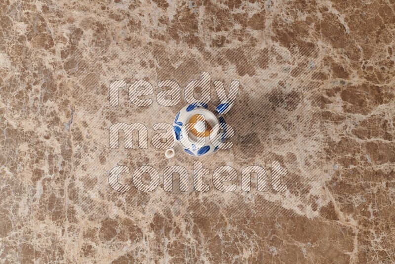 إبريق شاي فخاري على خلفية رخام بيج