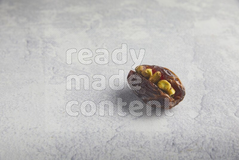 pistachio stuffed madjoul date on a light grey background
