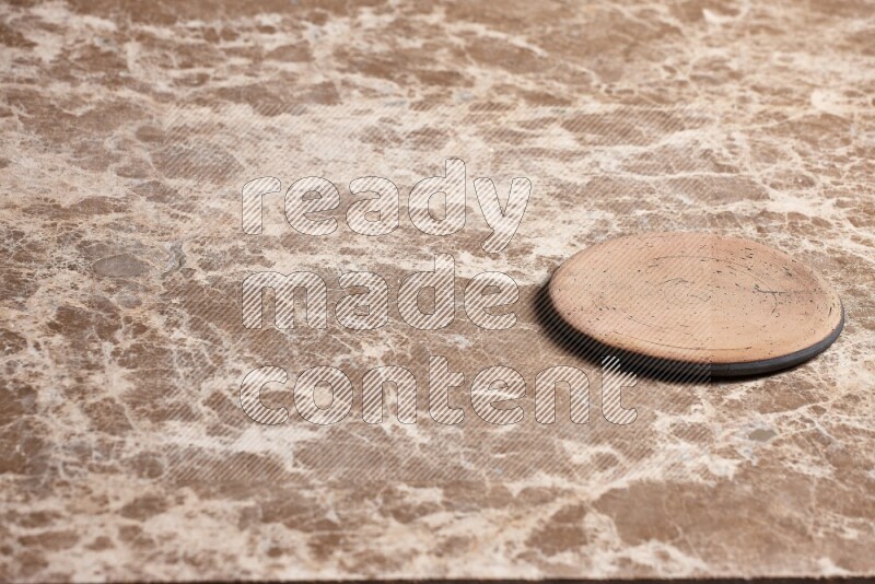A pottery coaster on beige marble background
