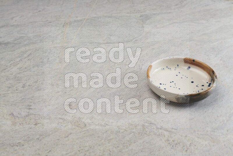 A multicolored pottery bowl on grey marble background