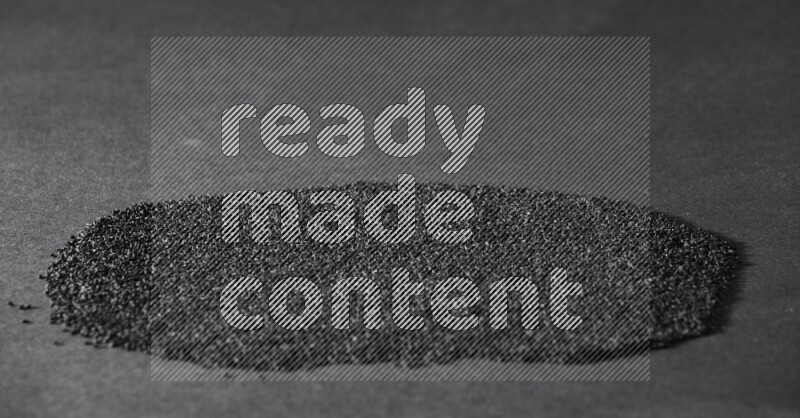 Black seeds filling the frame on a black flooring