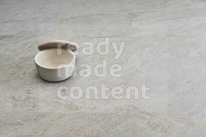 A white pottery bowl on grey marble background