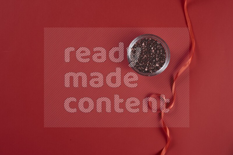A red collection of sewing and tailoring tools arranged on a red background