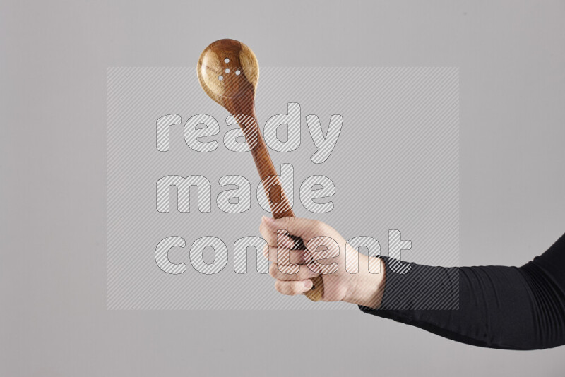 A woman in black abaya holding different wooden essentials in different positions