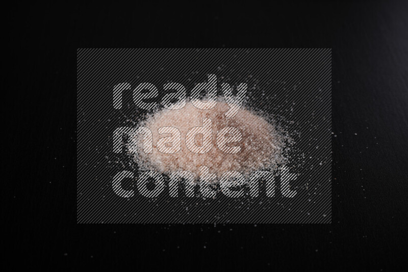 A bunch of fine himalayan pink salt on black background