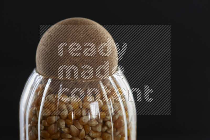 Pop corn in a glass jar on black background