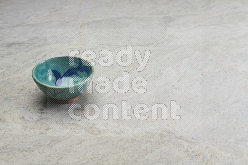 A multicolored pottery bowl on grey marble background