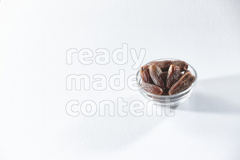 A glass bowl full of dried dates on a white background in different angles